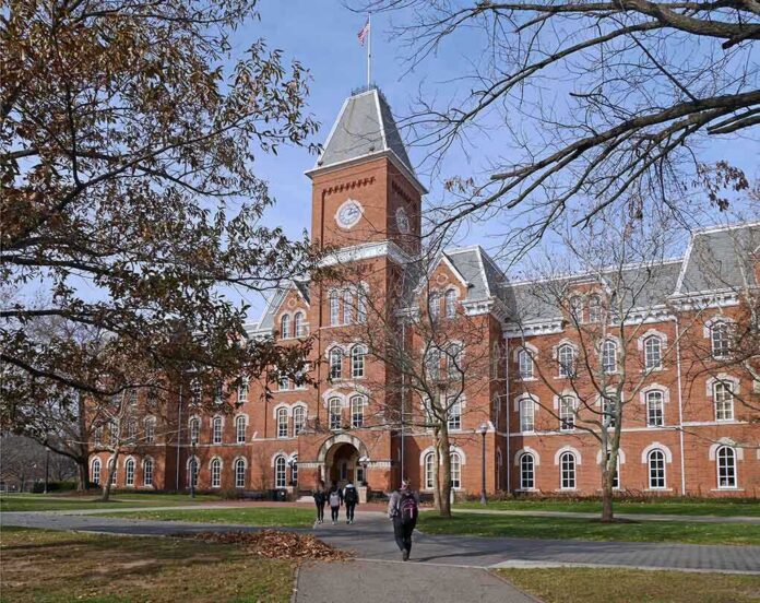 shutterstock_238536373 Historic university building with students walking in front during autumn