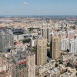 Public Buyouts or Seizure? The Truth Revealed Aerial view of a sprawling urban city with high-rise buildings and green spaces