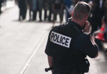 Police officer in uniform communicating with a crowd in an urban setting