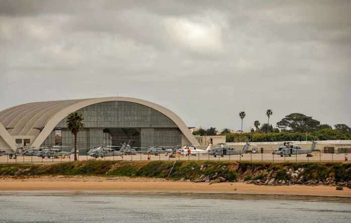 1086141389 Aircraft hangar with helicopters near the beach.