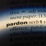 Biden-Era Bust, Trump Pardon Twist The word pardon highlighted in a dictionary.