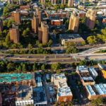 Aerial view of urban area with tall buildings and freeway.