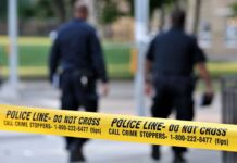 Impostor Panic: DEA Badge, Guns, Chemicals Police officers walking past caution tape at a crime scene