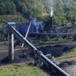 $700M Coal Play Rattles Energy Crowd Industrial coal processing facility with conveyor belts and smoke stack