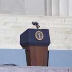Trump Freezes Strikes—Deal Looms? Podium with a microphone and presidential seal in front of steps