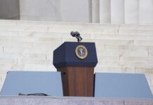 Trump Freezes Strikes—Deal Looms? Podium with a microphone and presidential seal in front of steps