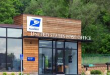 Exterior view of a modern United States Post Office building surrounded by greenery