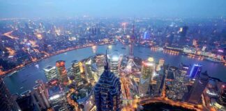 Aerial view of Shanghais skyline at night with illuminated buildings and a river