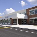 Modern school building with large windows and a clear sky