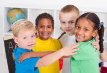Hundreds Of Kids Vanish — What ICE Missed Four children of diverse backgrounds smiling and hugging each other in a classroom