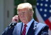 Brief Illness, Big Questions—Trump Weighs In Man in a suit adjusting an earpiece.