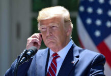 Brief Illness, Big Questions—Trump Weighs In Man in a suit adjusting an earpiece.
