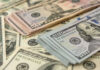 Trump Stamps The $100 Bill — New Tradition Stacks of various U.S. dollar bills.