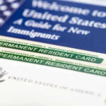 Birthright Ruling Triggers Dangerous New Crackdown Permanent resident cards with welcome guide and flag.