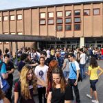 Nine Overdoses. Board Says No Teacher Testing A large group of students socializing outside a school building