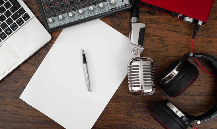 Podcast workspace with microphone, headphones, and blank paper