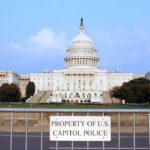 Troops Till 2029: What’s Really Going On? View of the U.S. Capitol building with a security barrier in front