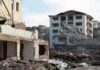 Collapsed apartment buildings amid heavy rubble