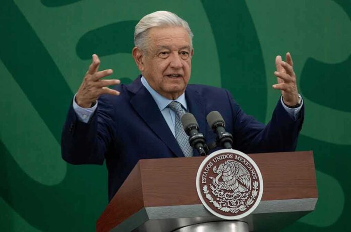 man at podium speaking with raised hands