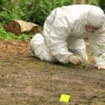 No Foul Play? Family Explodes Forensic investigator in a protective suit collecting evidence from the ground