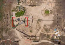 Aerial view through drone HUD of archaeological ruins and surrounding campsite
