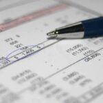 Close-up of a financial document with highlighted numbers and a pen