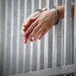 Teen’s “Perfect” Text Sparks Murder Theory handcuffed hands resting through prison bars