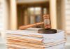 judge's gavel resting on a stack of case files