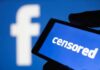 smartphone screen showing the word censored against a blue social media logo backdrop