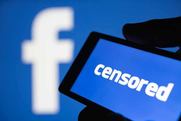 shutterstock_1179618787 smartphone screen showing the word censored against a blue social media logo backdrop