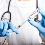 Private Fauci Miscarriage Warning Jolts Washington Healthcare worker drawing vaccine from vial with syringe
