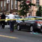 Brooks Road Bloodbath—Then Officials Go Dark Police at urban street crime scene with yellow tape around parked cars