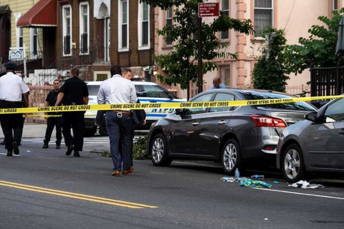 shutterstock_1437619232 Police at urban street crime scene with yellow tape around parked cars