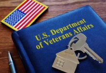 VA folder with house keychain and US flag patch on wooden desk