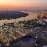 Industrial oil refinery complex beside a river at dusk