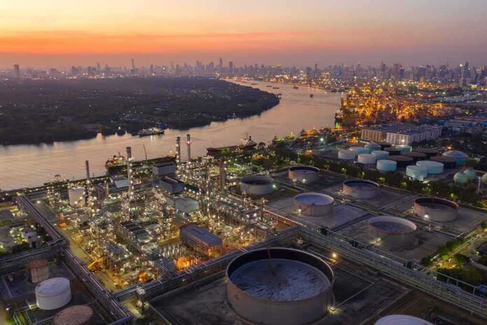 Industrial oil refinery complex beside a river at dusk