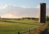 Brick silo beside a golf course at sunset