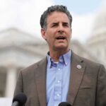 Mystery Aide Becomes Trump’s Lightning Rod man speaking at outdoor podium near government building