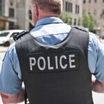 Burglar Shot — Then Demands Millions Police officer in uniform from behind on a city street