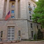 Stone government building with American flag at entrance
