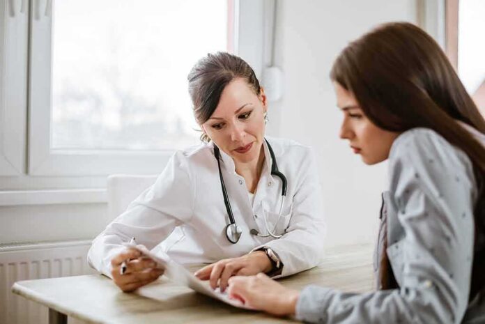 shutterstock_796803439 Doctor consulting a patient at a desk