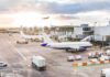 One Glitch, Three Airports Paralyzed Airplanes at airport gates during sunset with ground vehicles and jet bridges
