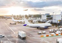 One Glitch, Three Airports Paralyzed Airplanes at airport gates during sunset with ground vehicles and jet bridges