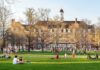 China Ties Ignite Federal Probe Into Top Universities Students relaxing on a campus quad in front of a brick academic building