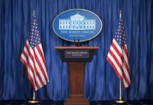 White House press podium with microphones and two American flags