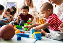 Judge Slams Daycare Bans On Vaccines Karyn Polito with toddlers building blocks on a play mat