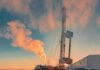 Oil drilling rig at sunset releasing steam