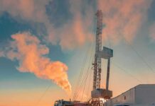 Trump’s $15B Steel Gamble Stuns Iowa Oil drilling rig at sunset releasing steam