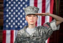 In-Flight Emergency Sparks Iran War Questions soldier in camouflage uniform saluting in front of a U.S. flag