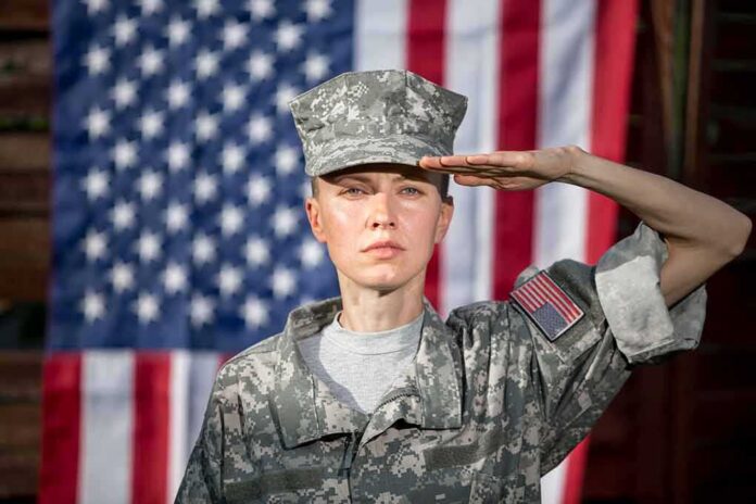 shutterstock_1416735905-1 soldier in camouflage uniform saluting in front of a U.S. flag